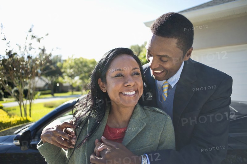 Couple hugging near convertible