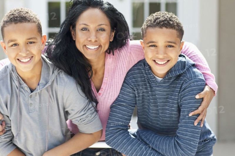 Close up of mother hugging sons outdoors