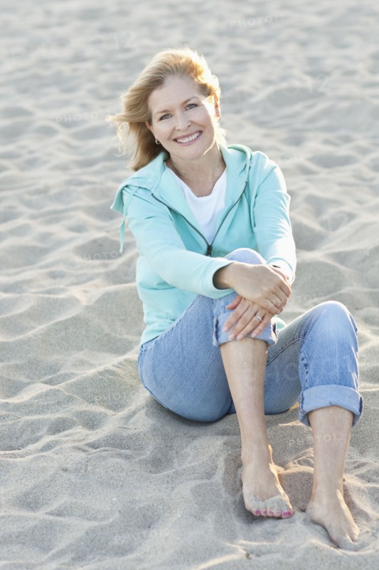 Caucasian woman sitting on beach
