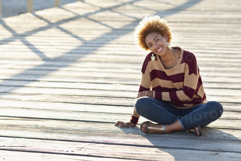 Black woman sitting on wooden boardwalk