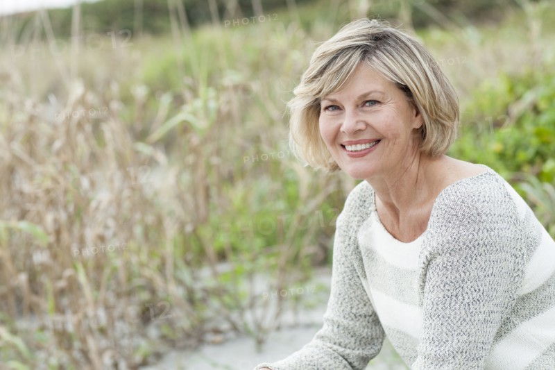 Smiling Caucasian woman sitting on beach