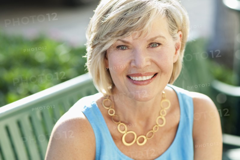 Smiling Caucasian woman sitting on bench