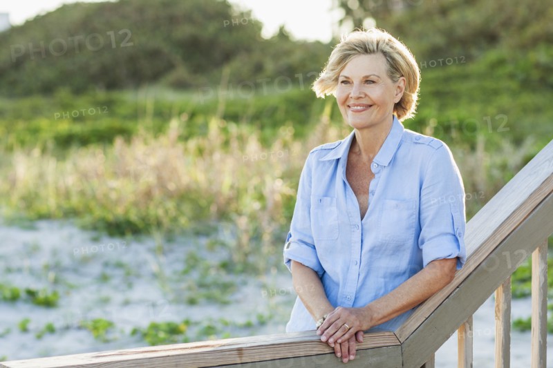 Smiling Caucasian woman standing on beach