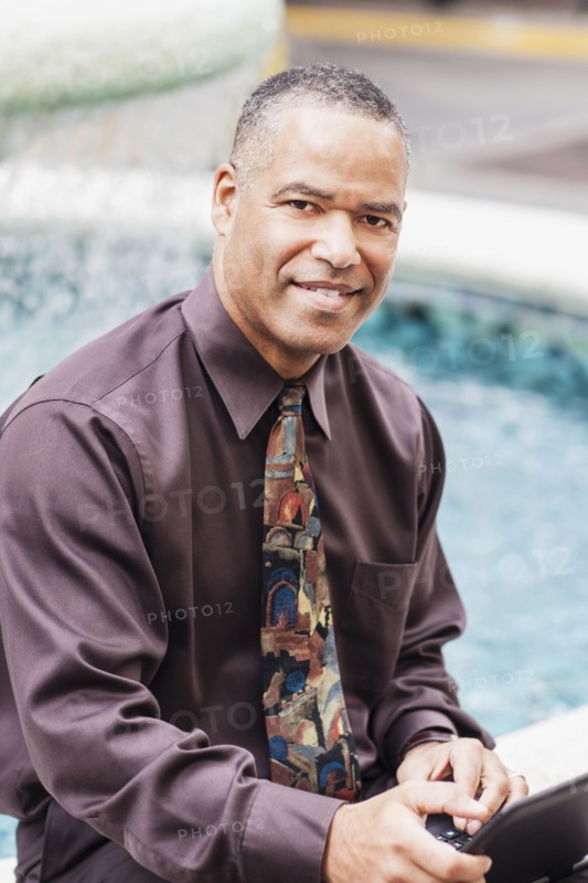 African American businessman working at fountain