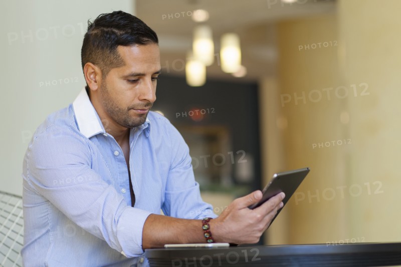 Hispanic man using digital tablet
