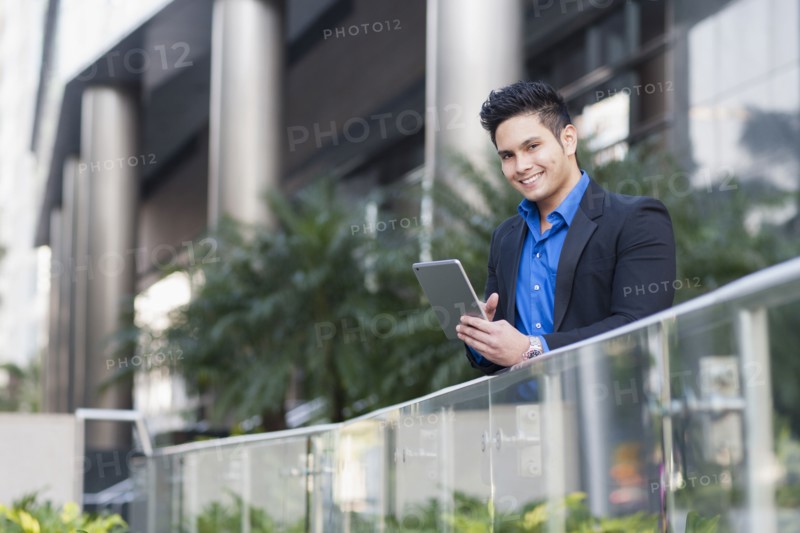 Mixed race businessman using digital tablet outdoors