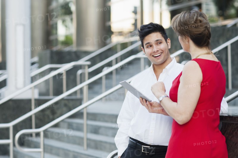 Business people using digital tablet near staircase
