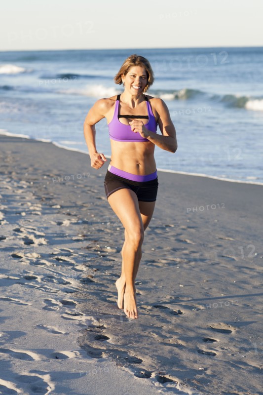 Caucasian woman jogging on beach