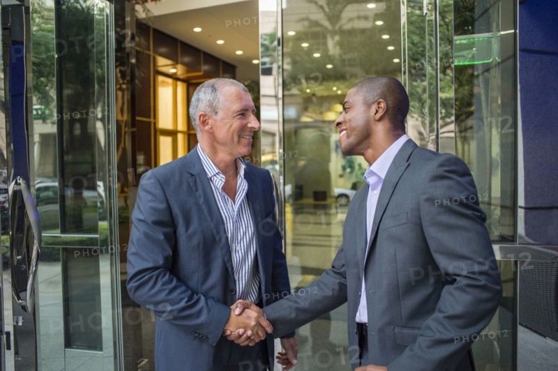 Businessmen shaking hands at office building