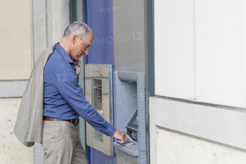 Caucasian businessman using ATM
