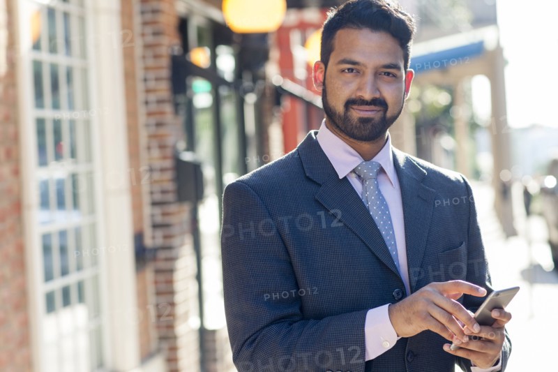 Indian businessman using cell phone in city