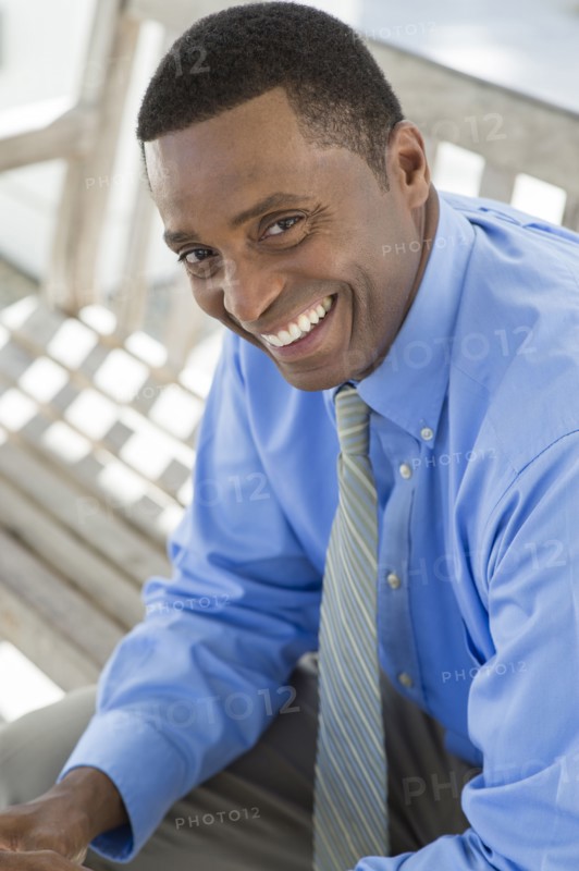 Black businessman smiling on bench