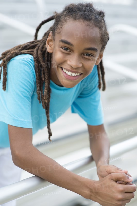 Mixed race boy smiling on bleachers