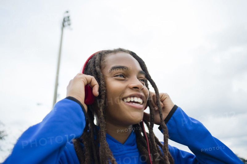 Mixed race boy listening to headphones outdoors
