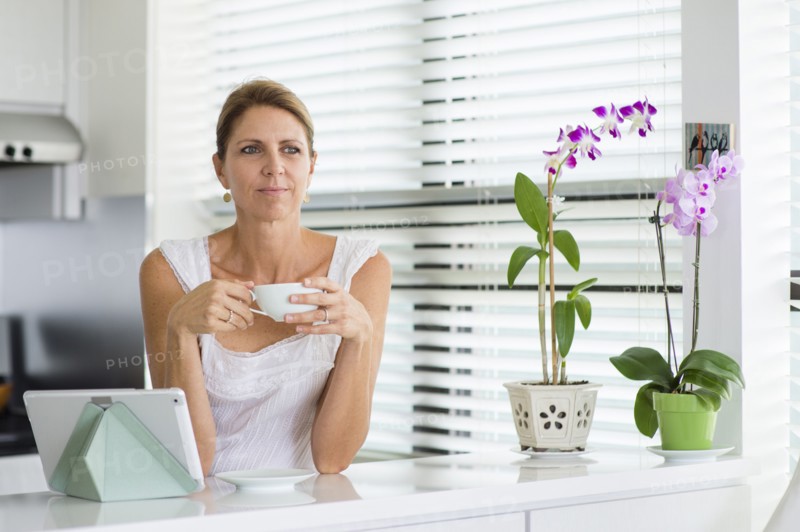 Caucasian woman drinking coffee in kitchen