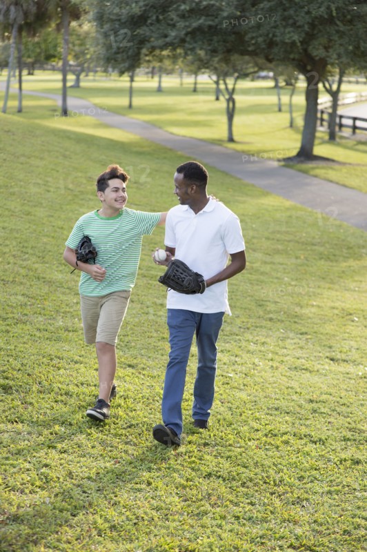 Father and son playing catch in park