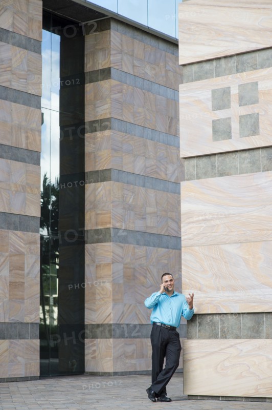 Caucasian businessman talking on cell phone outdoors