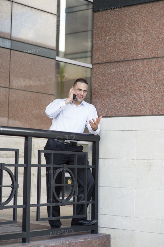 Caucasian businessman talking on cell phone outdoors