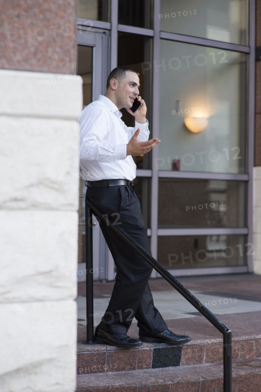 Caucasian businessman talking on cell phone outdoors