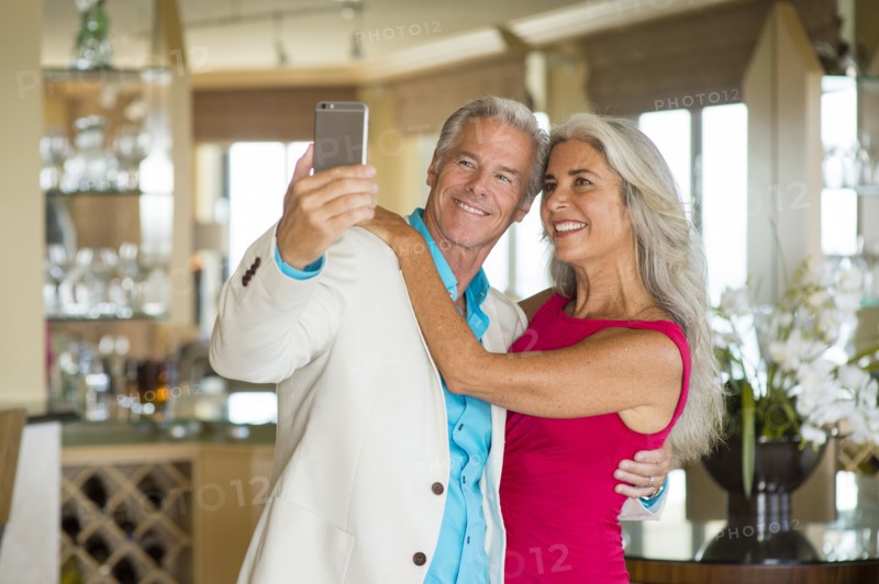 Older Caucasian couple taking selfie