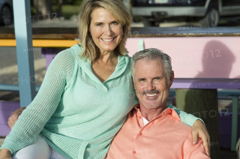Older Caucasian couple hugging outdoors