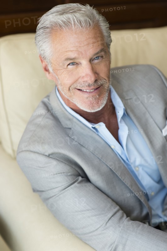 Smiling Caucasian man sitting on sofa