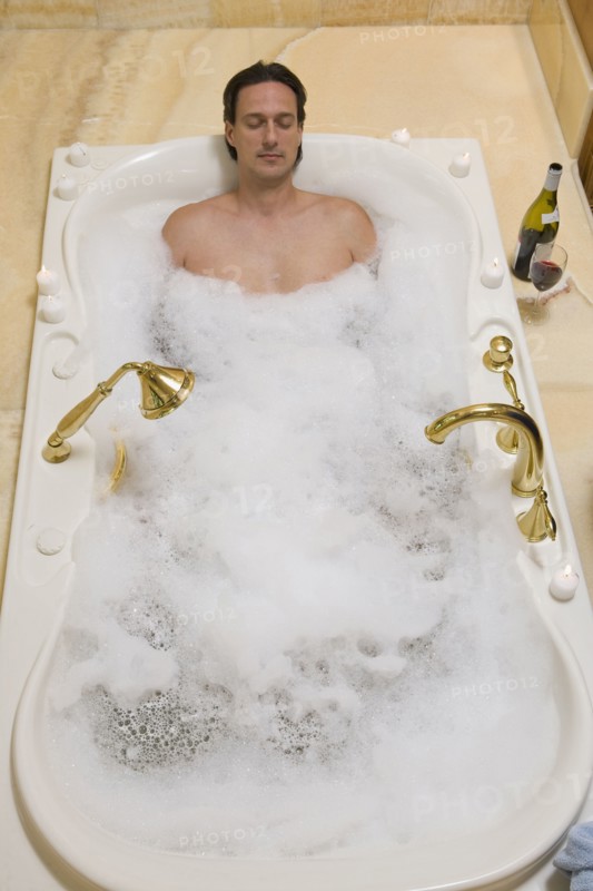 Hispanic man relaxing in bubble bath