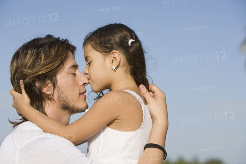 Hispanic girl kissing father