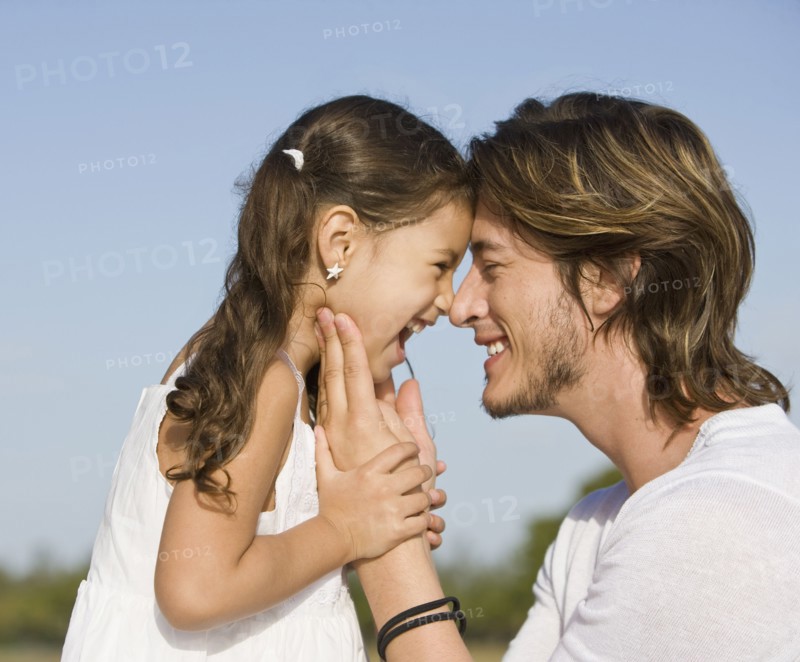 Hispanic father and daughter smiling at one another