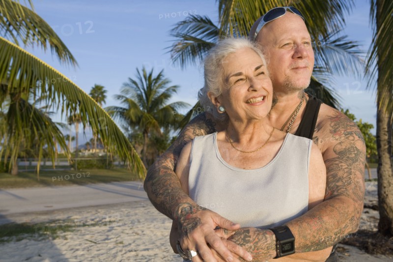 Mother and tattooed son hugging at the beach