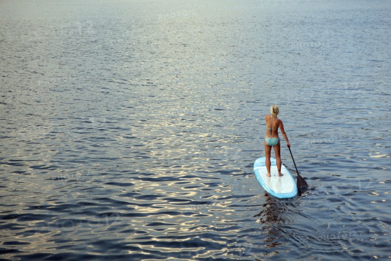 Caucasian woman on paddleboard on lake