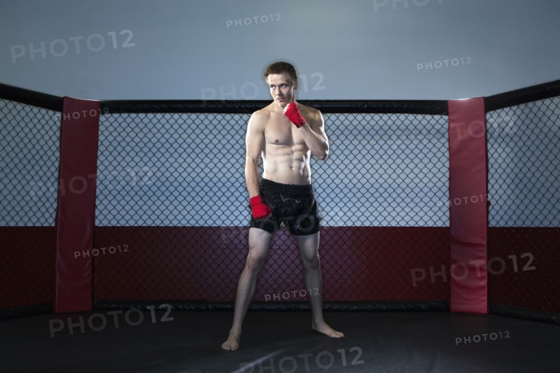 Caucasian cage fighter standing in ring