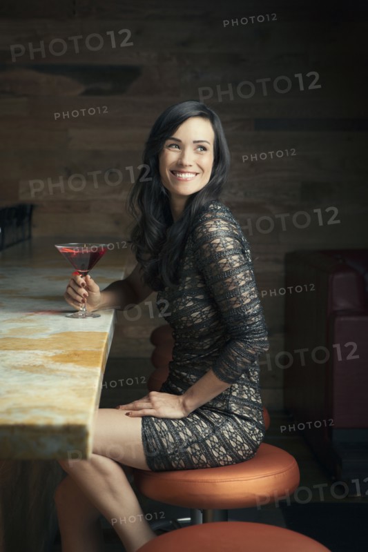 Hispanic woman smiling at bar