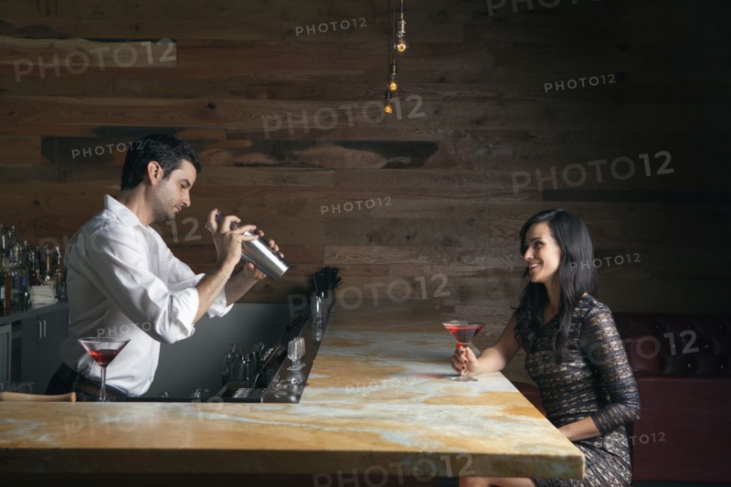 Hispanic woman having drink at bar
