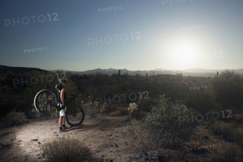 Mountain biker standing in desert