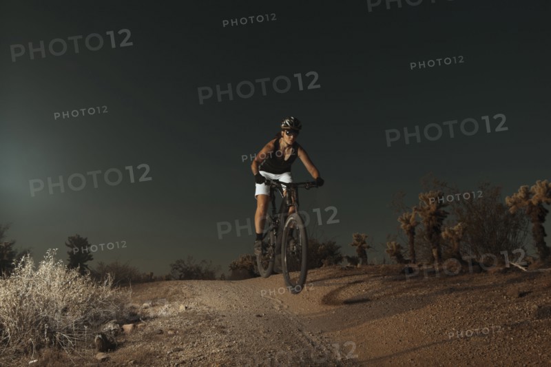 Woman riding mountain bike in desert