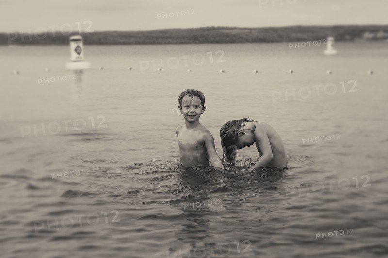 Caucasian boys swimming in lake