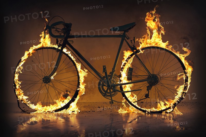 Silhouette of bicycle with flaming tires