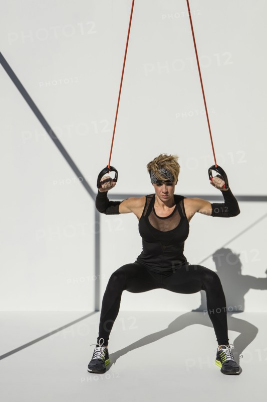 Caucasian athlete exercising with resistance cables