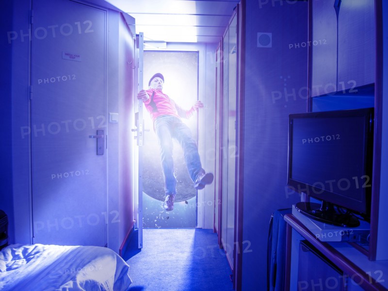 Caucasian man flying in bedroom