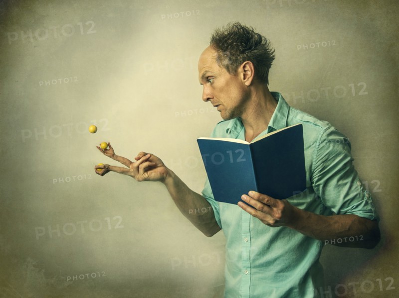Caucasian man juggling fruit with finger hands