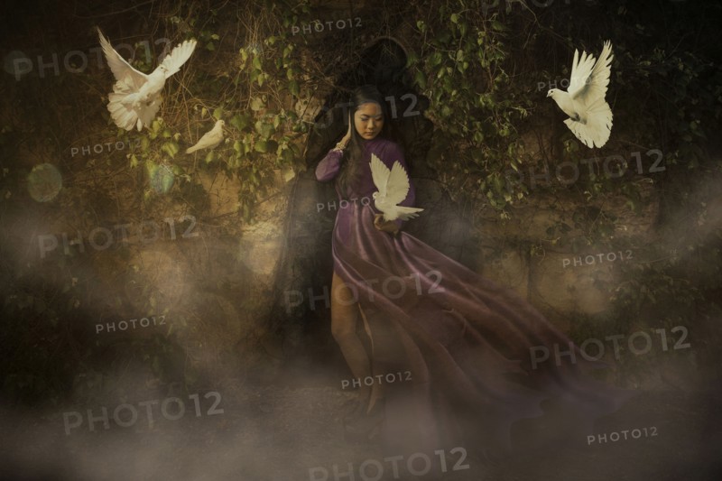 White doves flying around Chinese woman