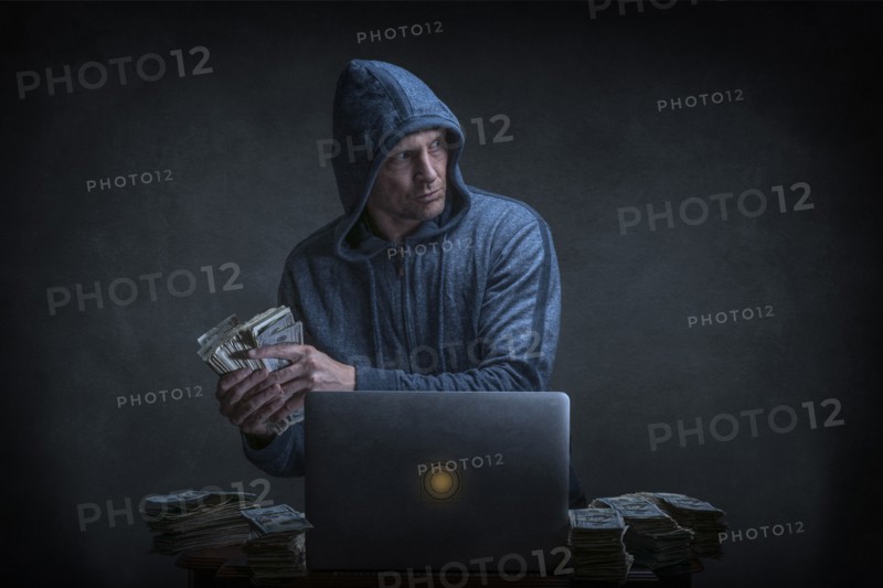 Caucasian hacker stealing money from laptop