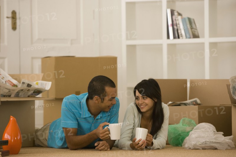 Young couple next to unpacked moving boxes