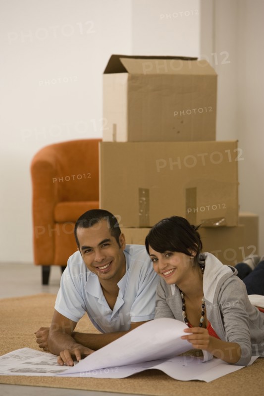 Young couple looking at blueprints in new house
