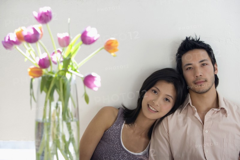 Asian couple next to flowers in vase