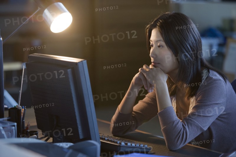 Asian businesswoman looking at computer