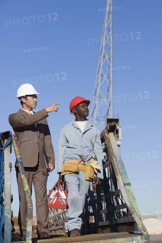 Multi-ethnic businessman and construction worker walking
