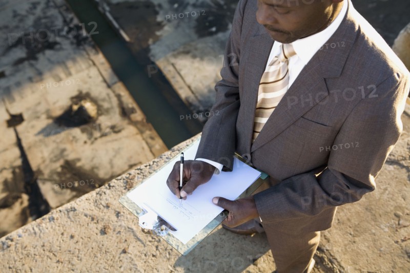 African American businessman writing on clipboard