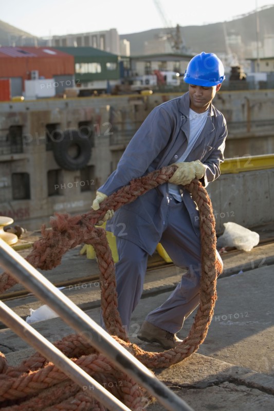 African American manual worker pulling on rope